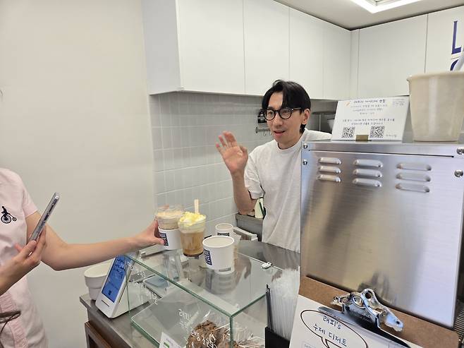 서울 중구 래피소드 카페에서 홍창현 래피소드 대표가 손님에게 메뉴를 설명 중이다. 정석준 기자
