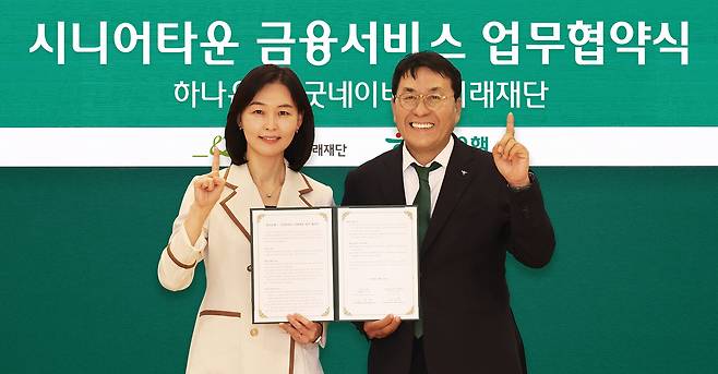 김진우(오른쪽) 하나은행 중앙영업그룹 부행장과 양진옥 굿네이버스 미래재단 대표가 지난 25일 서울 을지로 하나은행 본점에서 열린 업무협약식에서 기념촬영을 하고 있다. [하나은행 제공]