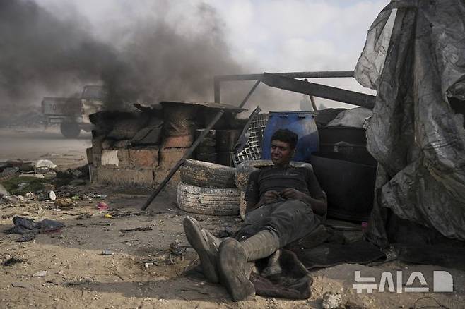 <font style="vertical-align: inherit;"><font style="vertical-align: inherit;">[가자시티=AP/뉴시스] 지난 22일(현지 시간) 가자지구 가자시티 남쪽 시로드에서 모하메드 나짐이라는 팔레스타인 청년이 플라스틱을 녹여 연료를 추출하는 작업 중 휴식하고 있다. 팔레스타인 청년들은 플라스틱 폐기물을 금속 드럼에 넣고 가열해 만든 연료를 병에 담아 판매하며, 이는 현지에서 발전기나 이동용 연료로 사용된다. 유독한 연기와 불길에 노출되는 고된 작업이지만, 이들에게는 가족의 생계를 이어가는 거의 유일한 수단이다. 2025.06.25.</font></font><font style="vertical-align: inherit;"><font style="vertical-align: inherit;"></font></font><font style="vertical-align: inherit;"><font style="vertical-align: inherit;"></font></font>