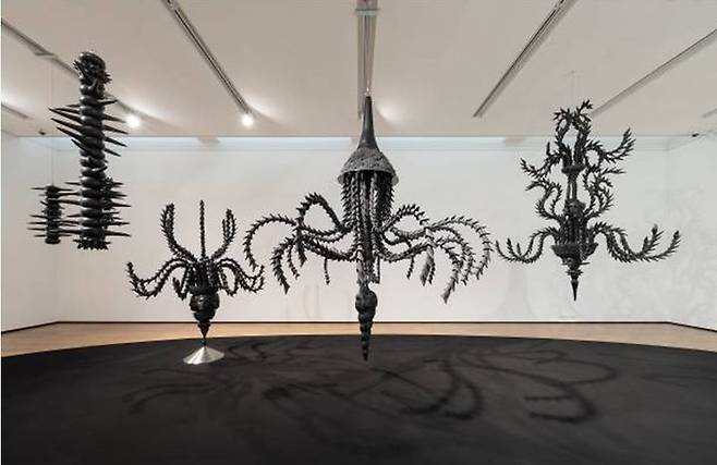 김미현 〈검은 무지개가 뜬 정원〉 전시 전경. 고전 샹들리에를 연상시키는 구조물은 도자 조각 파편들이 유기적으로 얽혀 형성된다. 매끄럽고 정교한 세라믹 표면은 꽃과 뼈, 촉수와 뿌리의 형태를 넘나들며 조각과 장식의 위계를 전복한다. *재판매 및 DB 금지