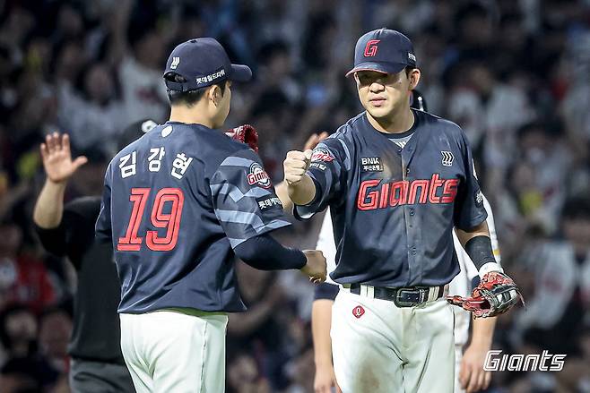롯데 김민성(오른쪽)이 25일 창원NC파크에서 열린 NC와 원정경기 6회말 구원등판한 김강현과 주먹을 맞대고 있다. 사진제공｜롯데 자이언츠