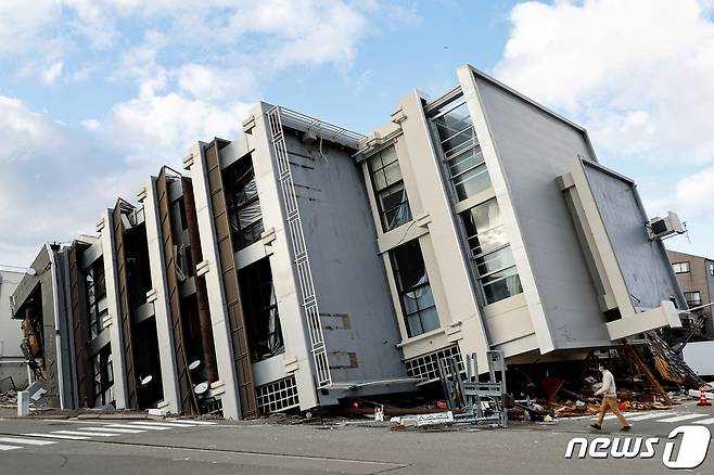 2024년 1월 4일 일본 이시카와현 와지마시에서 한 남성이 지진으로 쓰러진 건물 앞을 지나가고 있다. 혼슈 중서부 이시카와현 노토반도에서는 지난 1일 오후 4시 10분쯤 규모 7.6 강진이 발생했다. 2024.01.04 ⓒ 로이터=뉴스1 ⓒ News1 최종일 기자