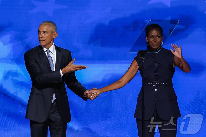버락 오바마 전 미국 대통령이 20일(현지시간) 일리노이주 시카고의 유나이티드 센터에서 열린 민주당 전당대회서 부인 미셸 여사와 인사를 하고 있다. 2024.08.21 ⓒ 로이터=뉴스1 ⓒ News1 우동명 기자