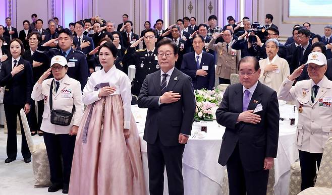 이재명 대통령과 부인 김혜경 여사가 27일 청와대 영빈관에서 열린 ‘호국보훈의 달, 대통령의 초대’ 행사에서 국기에 경례하고 있다. (대통령실통신사진기자단) 2025.06.27.