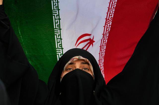 24일 한 이란 여성이 수도 테헤란 시내에서 열린 반미·반이스라엘 집회에서 자국 국기를 들고 있다. 테헤란=AP 연합뉴스