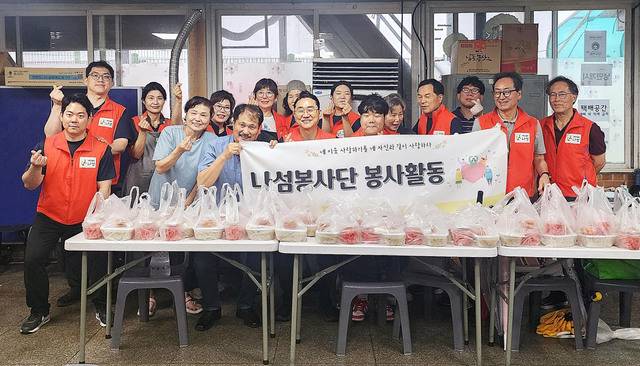 국명호(앞줄 왼쪽 네 번째) 여의도침례교회 목사가 지난 20일 서울 영등포구 광야교회에서 재단법인 나섬 봉사자들과 함께 쪽방촌 이웃들에게 전할 영양죽을 포장한 뒤 손하트 포즈를 취하고 있다.