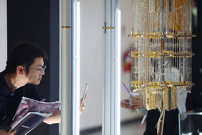 24일 서울 서초구 aT센터에서 열린 ‘퀀텀 코리아 2025’ 내 한국표준과학연구원 부스에서 관람객이 초전도 기반 50큐비트 양자컴퓨터 모형을 살펴보고 있다. [연합]