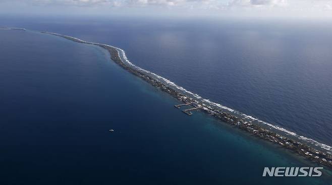 [푸나푸티(투발루)=AP/뉴시스]계속되는 해수면 상승으로 국가가 바닷물 속에 잠길 위기에 처한 투발루 국민의 3분의 1 이상이 호주로 영구 이주할 수 있는 세계 최초의 기후 비자를 신청했다고 BBC가 27일 보도했다. 항공기에서 촬영한 투발루 모습. 2025.06.27.