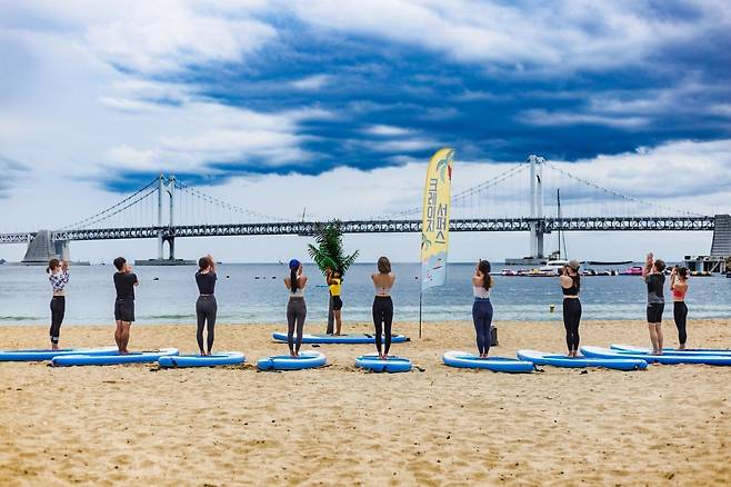 부산 광안리 해변에서 진행하는 SUP 요가.  11월까지 주말에만 운영하며 해변 SUP 요가는 오전 9시, 해상 SUP 요가는 오전 11시에 시작한다                         사진제공 ｜크레이지서퍼스