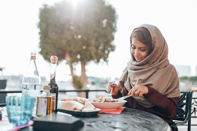 할랄 푸드를 먹고 있는 무슬림 여성 (사진=게티이미지뱅크)