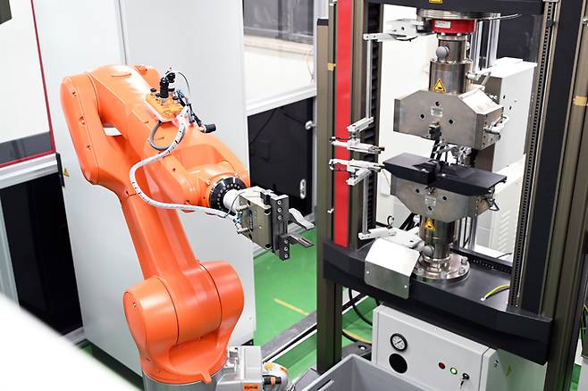 한국재료연구원이 구축한 '오토노머스 랩'에서는 로봇 팔 활용 자동 인장기가 사람 개입 없이 인장 실험을 수행한다.