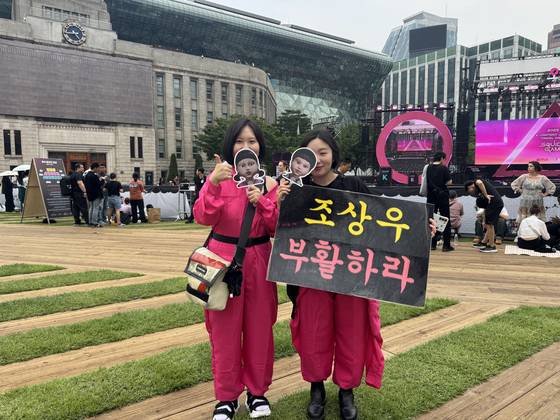 Lee Ju-won, left, and Lee Jin-ju, both wearing a Pink Guard costume from Netflix's ″Squid Game″ (2021-), pose for a photo during the show's grand finale event held at Seoul Plaza in central Seoul, on June 28. [KIM JI-YE]