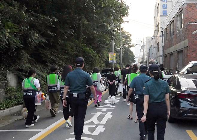 반려견 순찰대와 시민, 경찰이 함께 순찰을 돌며 마약 퇴치 캠페인 홍보물을 배부하고 있다. 부산시 제공