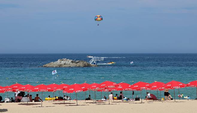개장 후 첫 휴일인 29일 강릉 경포해수욕장을 찾은 피서객들이 파라솔 밑에서 더위를 식히고 있는 모습. 연합뉴스