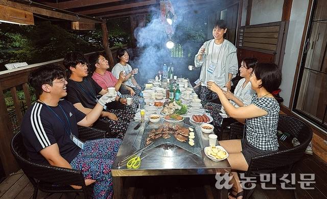 해가 저문 저녁에 식탁 앞에 모인 참가자들.