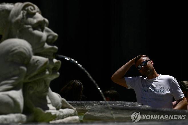 이탈리아 로마의 한 분수대에서 물로 머리를 식히는 관광객  [AFP 연합뉴스 자료사진 재판매 및 DB 금지]