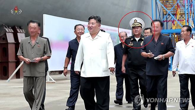 김정은 기록영화에 김명식 전 해군사령관 재등장 (서울=연합뉴스) 북한 조선중앙TV가 29일 방영한 기록영화 '위민헌신의 여정, 새로운 변혁의 2024년'에 김명식 전 해군사령관(빨간색 동그라미)의 모습이 삭제되지 않은 채 등장했다. 북한은 앞서 지난 13일 방영한 구축함 '강건호' 진수기념식 영상에서 김정은 국무위원장의 지난 3월 함선건조사업 현지시찰 사진을 재공개하면서 당초 김 위원장과 함께 있던 김명식 전 해군사령관을 완전히 삭제한 채 편집해 내보냈다. [조선중앙TV 화면] 2025.6.29 
    [국내에서만 사용가능. 재배포 금지. For Use Only in the Republic of Korea. No Redistribution] nkphoto@yna.co.kr