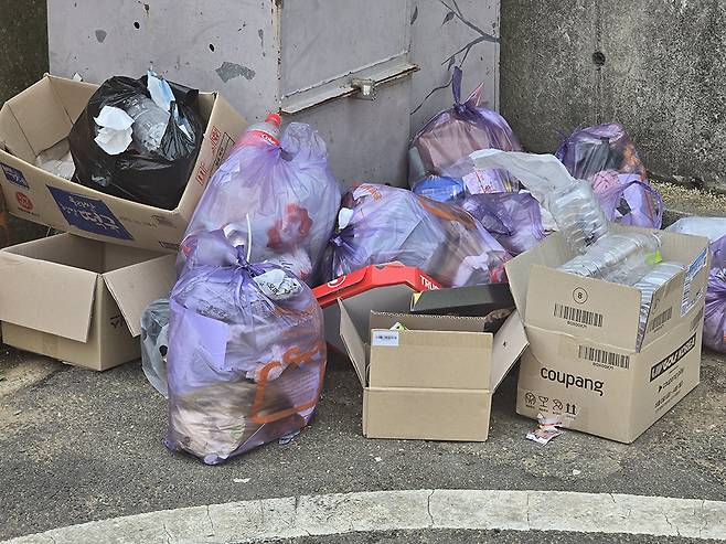 한 원룸촌 수거장 앞에 일반 쓰레기, 재활용품, 박스류가 뒤섞여 있다.