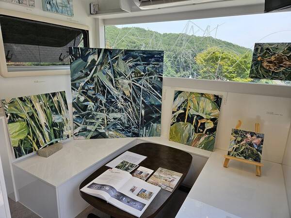 서수인 작가의 카라반 내부. 사라져가는 자연을 받아들이고 그린 그의 작품들을 유리창 너머 자연을 배경 삼아 배치하고, 유리창에는 간단한 드로잉을 남겼다. 백지영기자