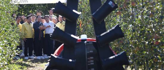 구인모 군수가 관계자들과 함께 과수 재배용 로봇 실증 시연을 참관하고 있다.