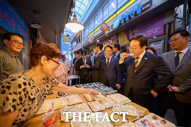 .이재명 대통령이 6월 20일 울산 울주군 언양알프스시장을 찾아 한 상점에서 떡을 먹어보고 있다. /대통령실