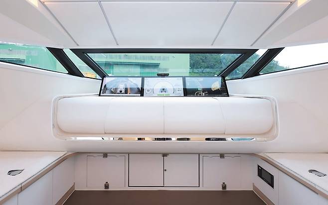 삼성중공업이 개발한 자율 운항 선박 ‘시프트 오토’가 경남 거제 앞바다를 달리고 있는 모습(위쪽 사진). 이 배는 출발지와 목적지만 설정하면 최적의 경로를 설정해 주위 장애물을 스스로 피해 가며 운항한다. 선박 내부(아래쪽 사진)에는 운전대도, 선장도 없다. 대신 대형 모니터 3대와 카메라, 음성 명령을 위한 마이크 등이 달려 있다./삼성중공업