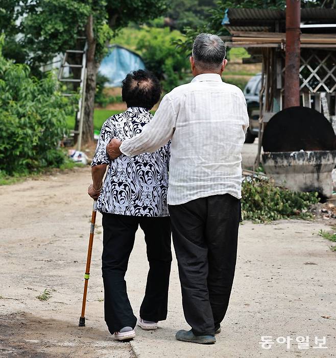 30일 오후 안무춘 씨(오른쪽)가 아내 김옥태 씨를 부축하며 동네를 산책하고 있다. 충남 서산시 해미면에 사는 안 씨 부부는 각각 2014, 2015년 치매 진단을 받았다. 서산=양회성 기자 yohan@donga.com
