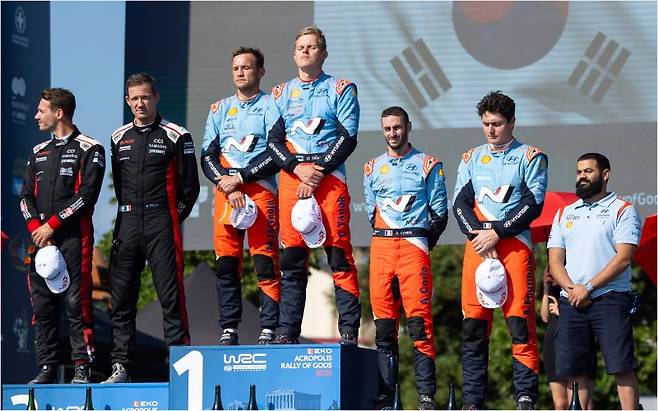 29일(현지시간) 그리스 라미아에서 열린 '2025 WRC' 시즌 7라운드에서 우승을 차지해 1등 시상대에 오른 현대 월드랠리팀 코드라이버 마틴 야르베오야(왼쪽)와 드라이버 오트 타낙이 기념촬영을 하고 있다. 현대자동차 제공