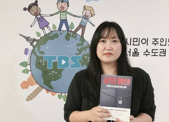 송지연 전국언론노동조합 티비에스(TBS)지부장이 최근 출간한 자신의 책 ‘공장폐쇄-TBS와 뉴스공장을 위한 변명’을 들고 있다. 송지연 제공
