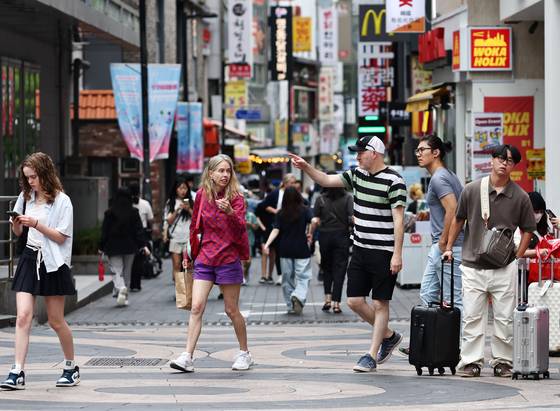 People walk along the streets of Myeong-dong in central Seoul on June 26. [YONHAP]