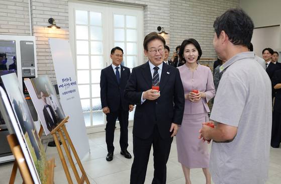 President Lee Jae Myung, center, and first lady Kim Hea Kyung speak with Kim Won-suk, director of Netflix series “When Life Gives You Tangerines,” at the Pine Grass reception hall in front of the Yongsan presidential office in central Seoul on June 30. [PRESIDENTIAL OFFICE]
