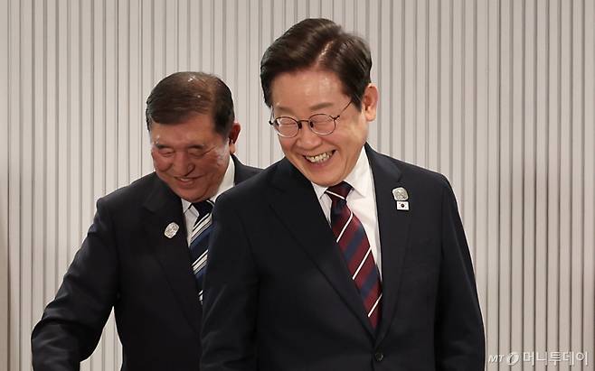 이재명 대통령이 지난 17일(현지시간) 캐나다 앨버타주 캐내내스키스 주요 7개국(G7) 정상회의장에서 열린 한일 정상회담에서 이시바 시게루 일본 총리와 밝게 웃으며 이동하고 있다. / 사진=뉴시스