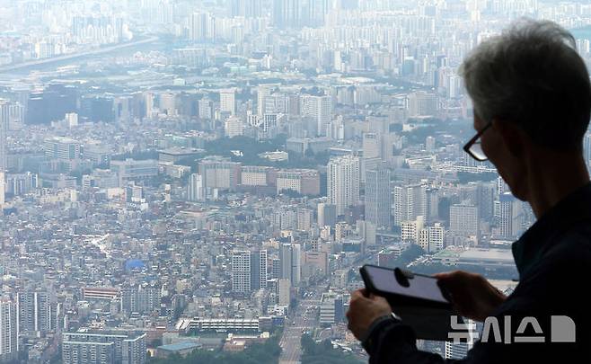 [서울=뉴시스] 박주성 기자 = 정부가 수도권과 규제지역의 주택담보대출 한도를 6억원으로 제한하는 초강수 조치를 펴면서 서울 아파트의 74%가 주담대 제한 영향권에 들게 된다는 분석이 나왔다. 부동산R114의 수도권 아파트 평균 시세를 보면 서울 전체 25개 구 가운데 18개 구의 대출액이 종전보다 줄어들 것으로 예상했다.  사진은 29일 서울 송파구 롯데월드타워 전망대 서울스카이에서 바라본 서울시내 아파트의 모습. 2025.06.29. park7691@newsis.com