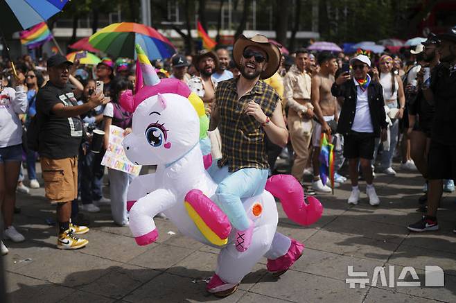 [멕시코시티=AP/뉴시스] 28일(현지 시간) 멕시코 수도 멕시코시티에서 열린 프라이드 퍼레이드에서 유니콘 분장을 한 남성이 행진하고 있다. 이번 행사는 '6월 성소수자(LGBTQ+) 인권의 달'을 마무리하는 일환으로 열렸다. 2025.06.29.
