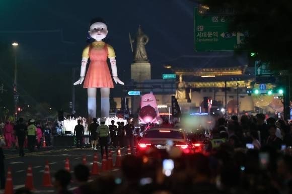 ‘오징어 게임’ 시즌3가 공개된 다음날인 지난 28일 서울 광화문광장 등에서 열린 ‘2025 K콘텐츠 서울여행주간 오징어 게임 퍼레이드’에 거대한 영희 인형이 등장해 우뚝 서 있다.  뉴시스