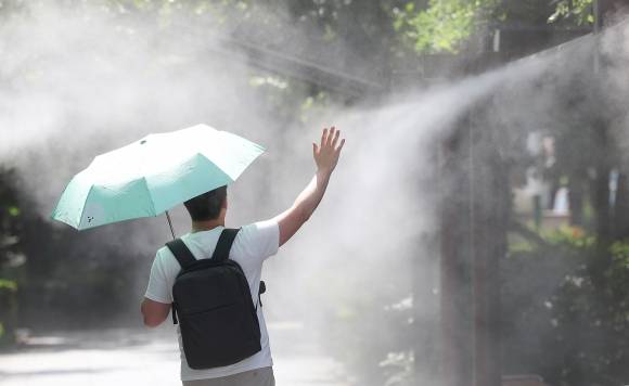 폭염 식혀주는 쿨링포그 - 대구에 폭염경보가 발효 중인 30일 대구 중구 국채보상운동기념공원에 쿨링포그(안개형 냉각수)가 가동 중인 가운데 한 시민이 양산을 들고 이동하고 있다. 2025.6.30 대구 연합뉴스