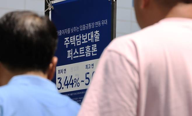 지난 15일 서울 시내 은행 앞 대출 홍보물을 지나는 시민들의 모습 ⓒ연합뉴스