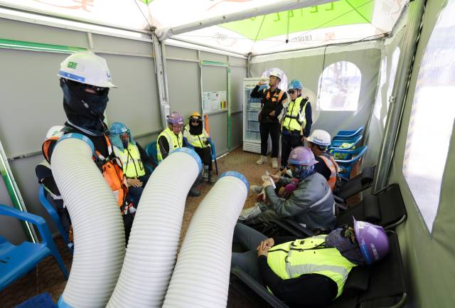 1일 부산 해운대구 재송동의 한 아파트 공사장에서 작업자들이 무더위를 피해 냉풍기가 설치된 야외 천막에서 휴식을 취하고 있다. 정대현 기자 jhyun@