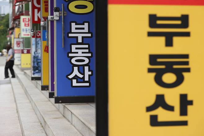 지난달 30일 서울의 한 부동산 중개업소 앞에 시민이 오가고 있다. 업계는 한동안 급매물 위주로만 간간이 거래가 성사되며 전체 거래도 크게 줄 것으로 보고 있다. (사진= 연합뉴스)