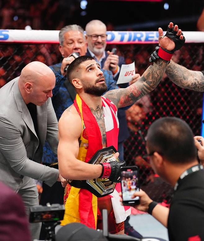 데이나 화이트 UFC 회장이 라이트급 챔피언으로 등극한 토푸리아에게 챔피언 벨트를 메주고 있다. 사진  | UFC