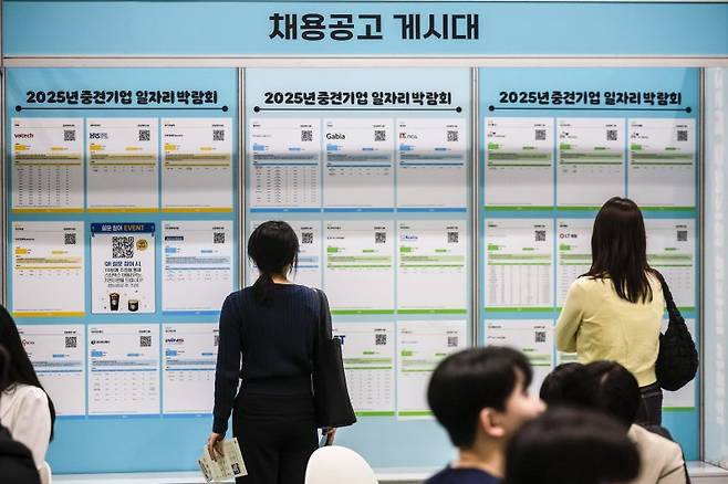 서울 강남구 코엑스에서 열린 2025년 중견기업 일자리 박람회를 찾은 구직자들이 채용정보 게시판을 살펴보고 있다. 뉴시스