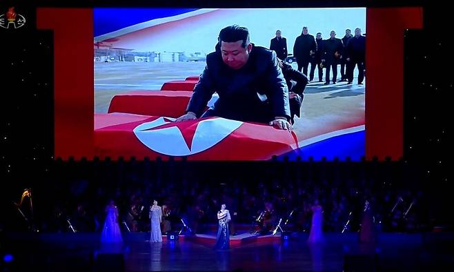 북한 조선중앙티브이(TV)가 지난달 29일 평양 4.25문화회관에서 방북 중인 올가 류비모바 러시아 문화부 장관이 참석한 가운데 열린 예술인 공연 중 무대 배경화면에 김정은 국무위원장이 러시아 파병 북한군 전사자 관을 어루만지며 애도하는 장면을 지난달 30일 공개했다. 연합뉴스