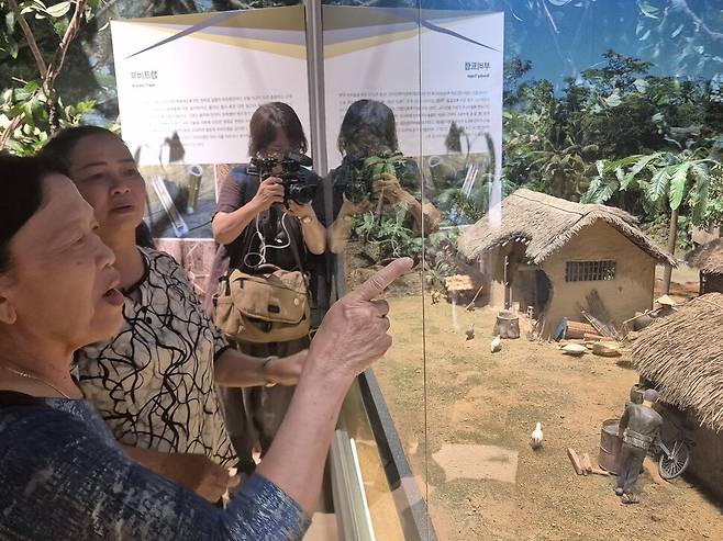 2025년 6월22일 서울 용산구 전쟁기념관 해외파병실을 방문한 베트남 하미마을의 응우옌티탄(68·맨 앞)과 퐁니마을의 응우옌티탄(65·앞에서 둘째)이 미니어처로 복원한 전쟁 당시 가옥을 살펴보며 말하고 있다.