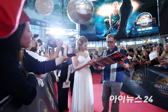 할리우드 배우 스칼렛 요한슨이 1일 오후 서울 영등포구 타임스퀘어에서 열린 영화 '쥬라기 월드: 새로운 시작' 내한 레드카펫 행사에 참석해 SNS 매거진과 인터뷰를 하는 중 사인지에 대신 사인을 받아주는 관계자의 모습. [사진=정소희 기자]
