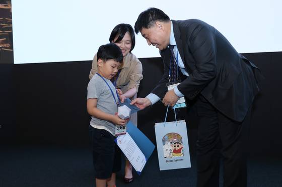 박중신 대한모체태아의학회장(오른쪽)이 학회에 참석한 강병수 서울성모병원 교수(가운데)의 7살 아들에게 표창장과 선물을 전달하고 있다.