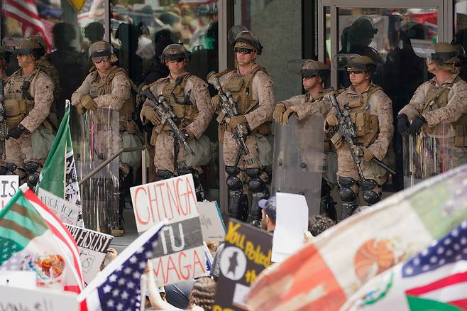 미국 캘리포니아주 로스앤젤레스(LA)에서 도널드 트럼프 미국 정부의 미등록 이민자 단속 정책에 반대하는 시위대가 해병대원들과 마주 서 있다. 로이터연합뉴스