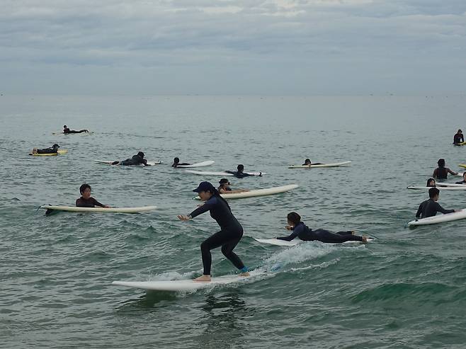 People surf at Naksan Beach, a popular spot for surfing located near Naksansa Temple in Yangyang County, Gangwon Province. (Cultural Corps of Korean Buddhism)