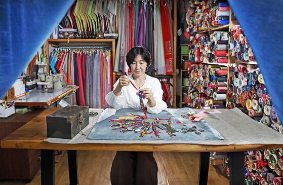 Jung Jung‑lan, a certified master of silken needlework, crafts a key tag at her Gain Hanbok Study in Gwangju, Gyeonggi. [PARK SANG-MOON]