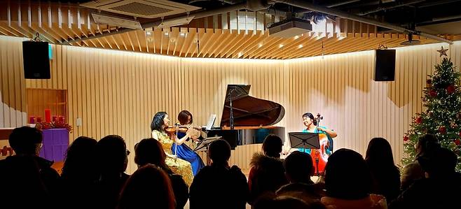 유경호 움오름교회 목사가 제빵 도구를 들고 화덕 앞에서 사진을 찍고 있다. 아래 사진은 움오름교회 쿰아트 단원들의 클래식 공연 모습. 움오름교회 제공