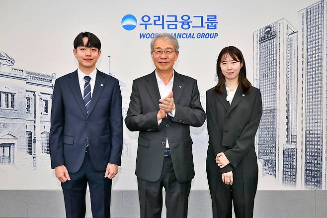 우리금융그룹 임종룡 회장(왼쪽)이 1일 서울 중구 우리금융지주 본사에서 그룹의 새 가족이 된 동양생명·ABL생명 직원에게 디지털 선도의 의미가 담긴 그룹 보조휘장을 달아주고 있다./사진=우리금융그룹